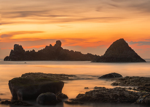 Ballintoy sea stacks and rocky coastline beneath a golden sunset in County Antrim, Northern Ireland by John taggart Landscapes.