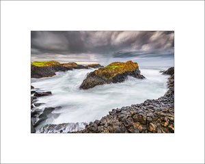 Waves and stormy skies among the sea stacks at Ballintoy Harbour County Antrim by John Taggart Landscapes