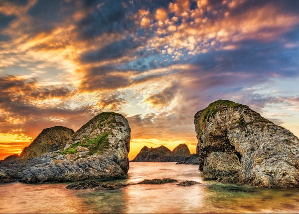 Ballintoy sea stacks at sunset, County Antrim Northern Ireland, dramatic coastal rock formations with colourful sky and calm sea