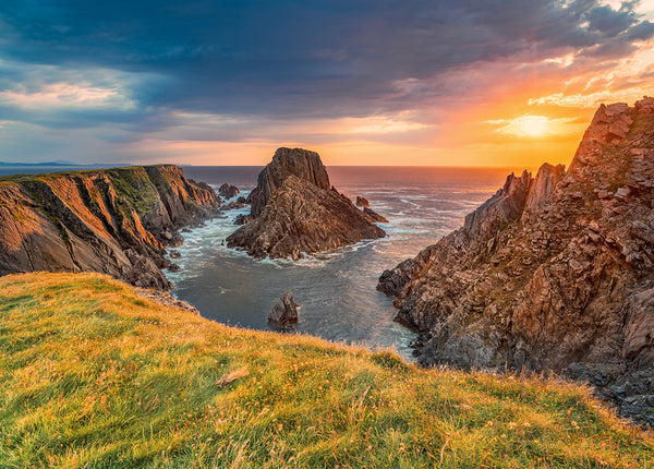 Sunset over Bamba’s Crown at Malin Head in County Donegal, Ireland, with dramatic coastal cliffs, Atlantic Ocean waves and golden evening light.