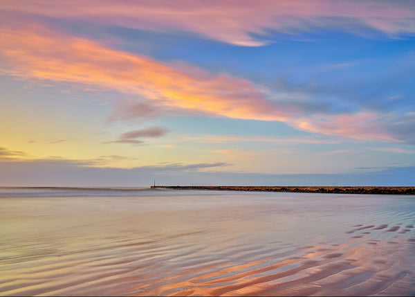 Castlerock Beach sunset with pastel sky and rippled sand leading to pier Northern Ireland landscape photo