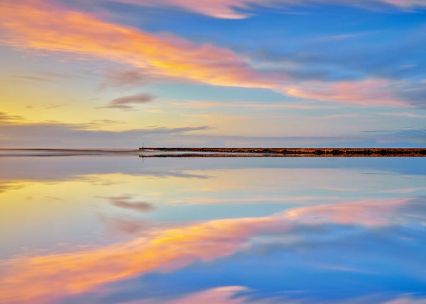 "Colorful sunset reflection of Castlerock Pier on still waters in Northern Ireland coastal landscape photography."