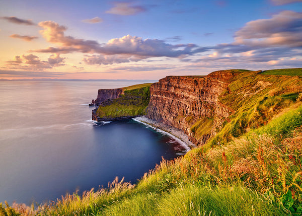 Cliffs of Moher County Clare Ireland in summer with golden light grassy foreground and Atlantic Ocean view