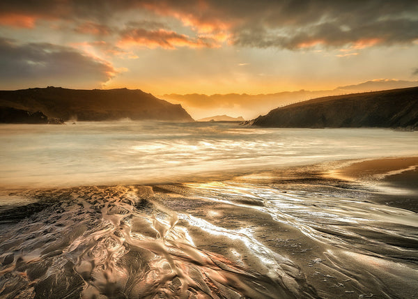 Clogher Strand Kerry Ireland sunset beach with golden reflections and flowing sand textures long exposure