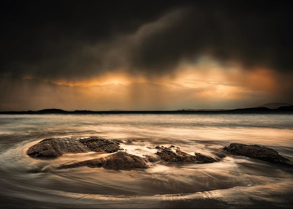 Connemara seascape in Galway Ireland with storm clouds and waves over coastal rocks