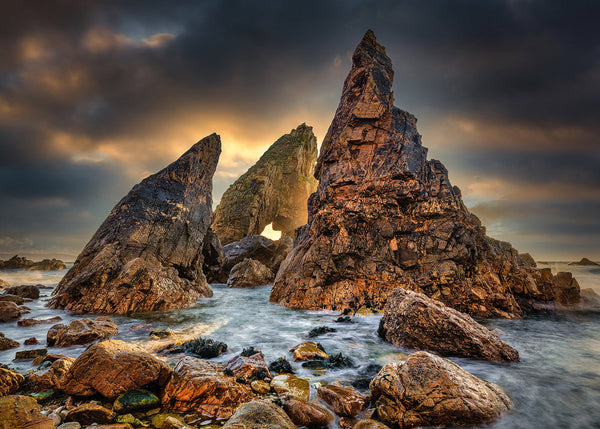 Golden sunset illuminating the Crohy Head Sea Arch and rugged sea stacks along the Wild Atlantic Way in County Donegal, Ireland. Fine art landscape photography by John Taggart.