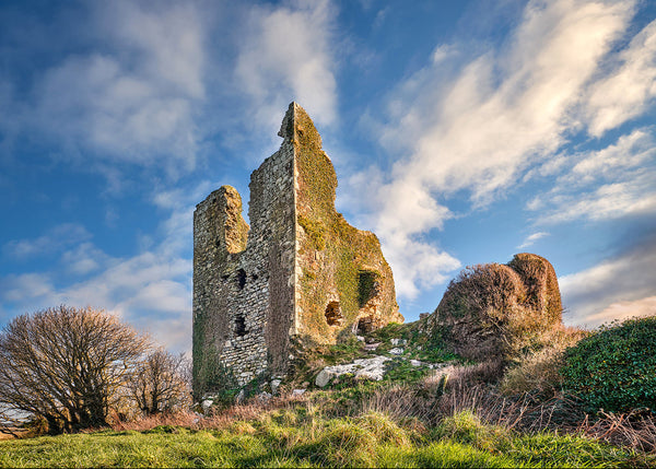 Dunhill Castle ruins in County Waterford, Ireland under blue sky.