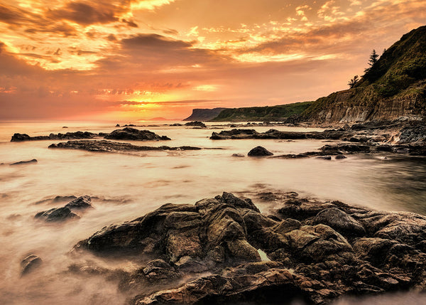 Sunset photo print looking over a rocky coastline at Fair Head in County Antrim Northern Ireland