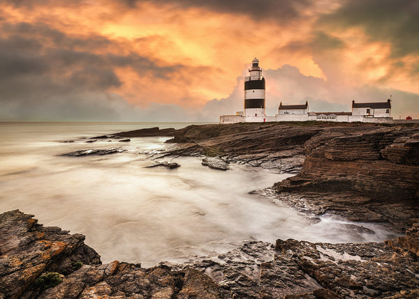 Hook Lighthouse at sunset on the County Wexford coast with dramatic sky and long exposure sea