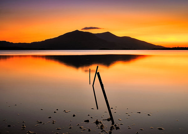 Sunset over Killarney lakes with mountain silhouette and reflection Irish landscape photography