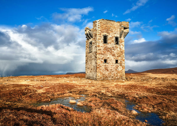 Glencolumcille watchtower in Donegal Ireland with dramatic sky and rugged landscape terrain
