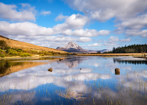 Errigal Mountain reflected in Dunlewey Lough County Donegal Ireland with a blue sky and clouds