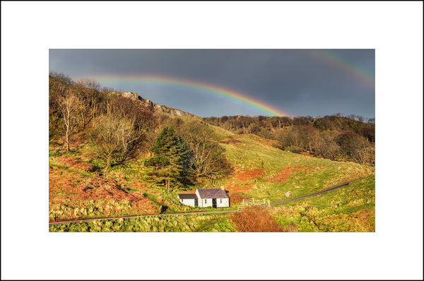 A beautiful rainbow appears over the little abandoned cottage on Murlough Bay County Antrim by John Taggart Landscapes