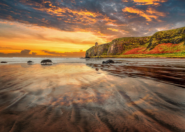Mussenden Temple sunset on the Causeway Coast Northern Ireland with reflections on wet sand