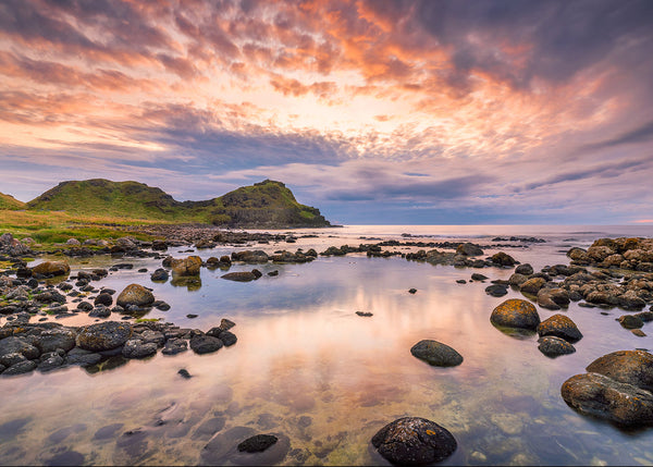 Pastel sunset reflections in rocky tidal pools along the Causeway Coast, Northern Ireland, by John Taggart Landscapes.