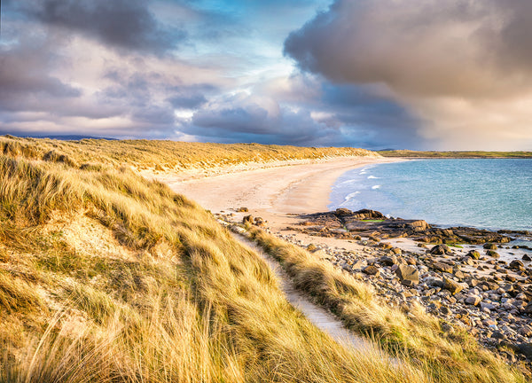 Port Arthur Beach in County Donegal with sand dunes and turquoise Atlantic water under dramatic skies
