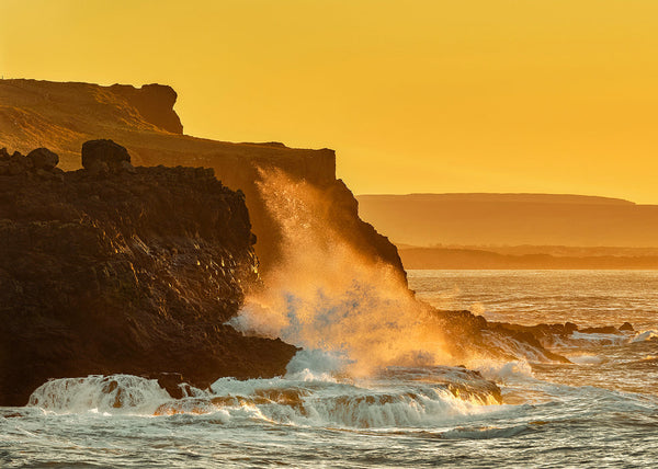 Golden sunset over rugged Antrim cliffs with waves crashing against rocks on the Wild Atlantic, Ireland landscape photography