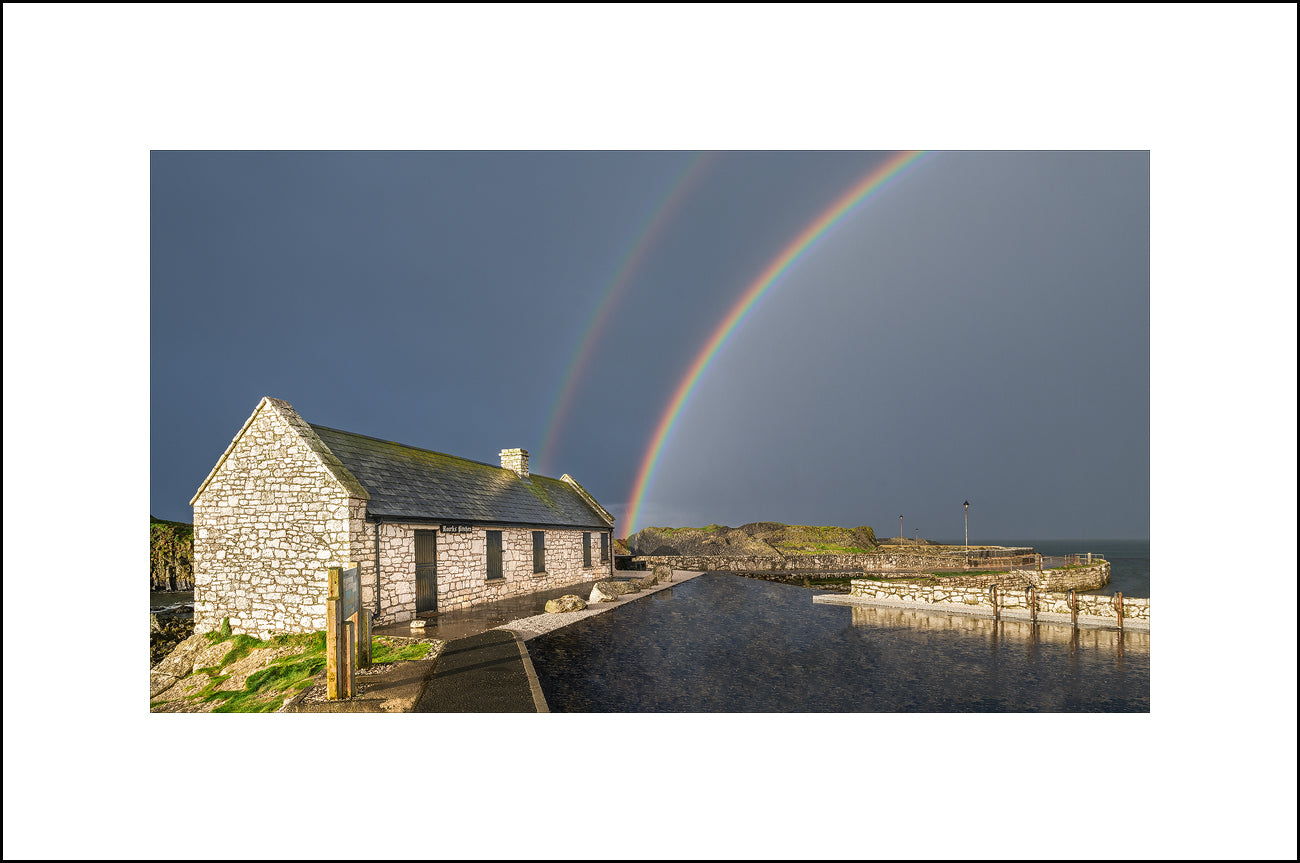 Stormy skies and beautiful rainbows at Ballintoy Harbour by John Taggart Landscapes