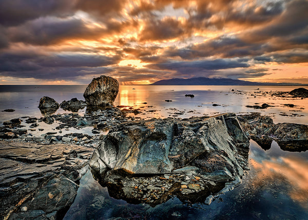 Sunset at Rossglass County Down with rocky shoreline dramatic clouds and reflections in tidal pools