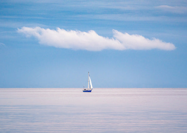 A beautiful calm evening at Lough Neagh in County Antrim as a lone sailing boat passes by.