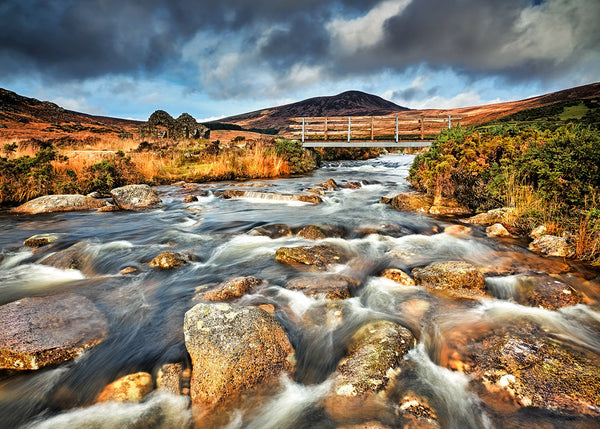Wicklow Gap river flowing over rocks beneath wooden bridge in Wicklow Mountains Ireland by Irish landscape photographer John Taggart