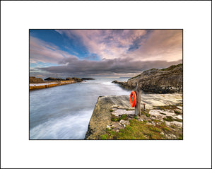 One of the lifebuoys stands guard at little Ballintoy Harbour in Co Antrim Northern Ireland By Irish Landscape Photographer John Taggart.