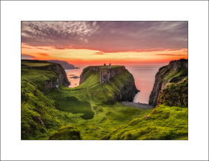 Summer sunset at Dunseverick Castle Ruins on the Causeway Coast, a majestic place on the Atlantic Ocean and at certain times of the year the sunsets are spectacular. By Irish landscape photographer John Taggart